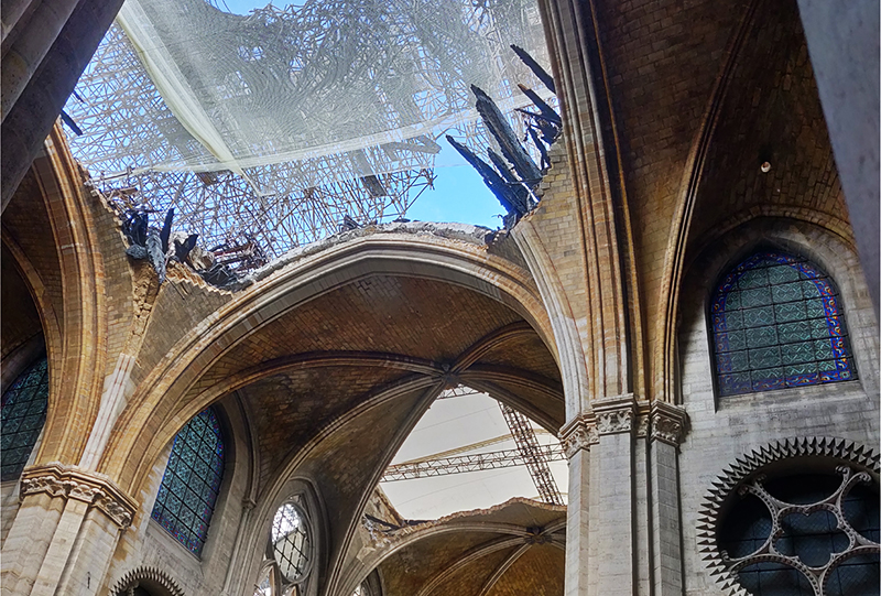 Ouverture dans la croisée du transept de Notre-Dame de Paris laissant apparaitre des poutres carbonisées